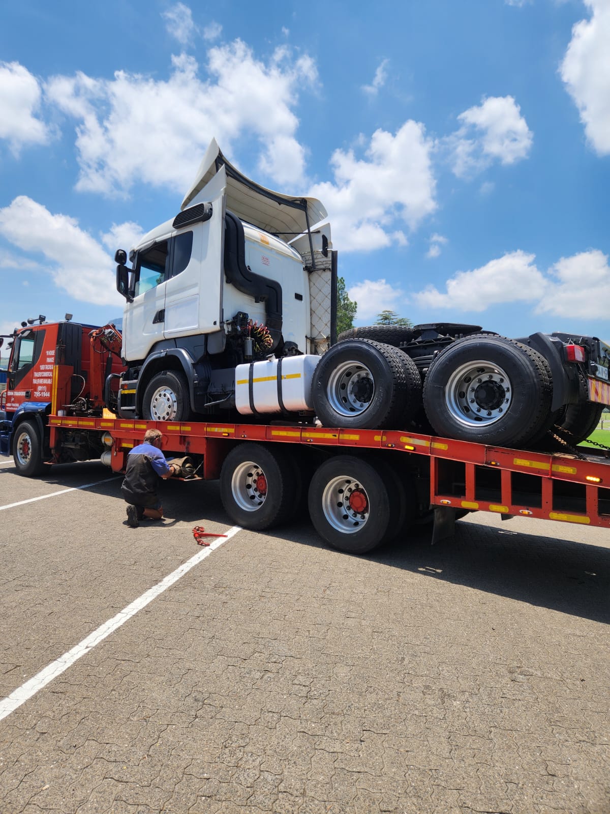 Crew strapping down a Scania truck horse on the carrier