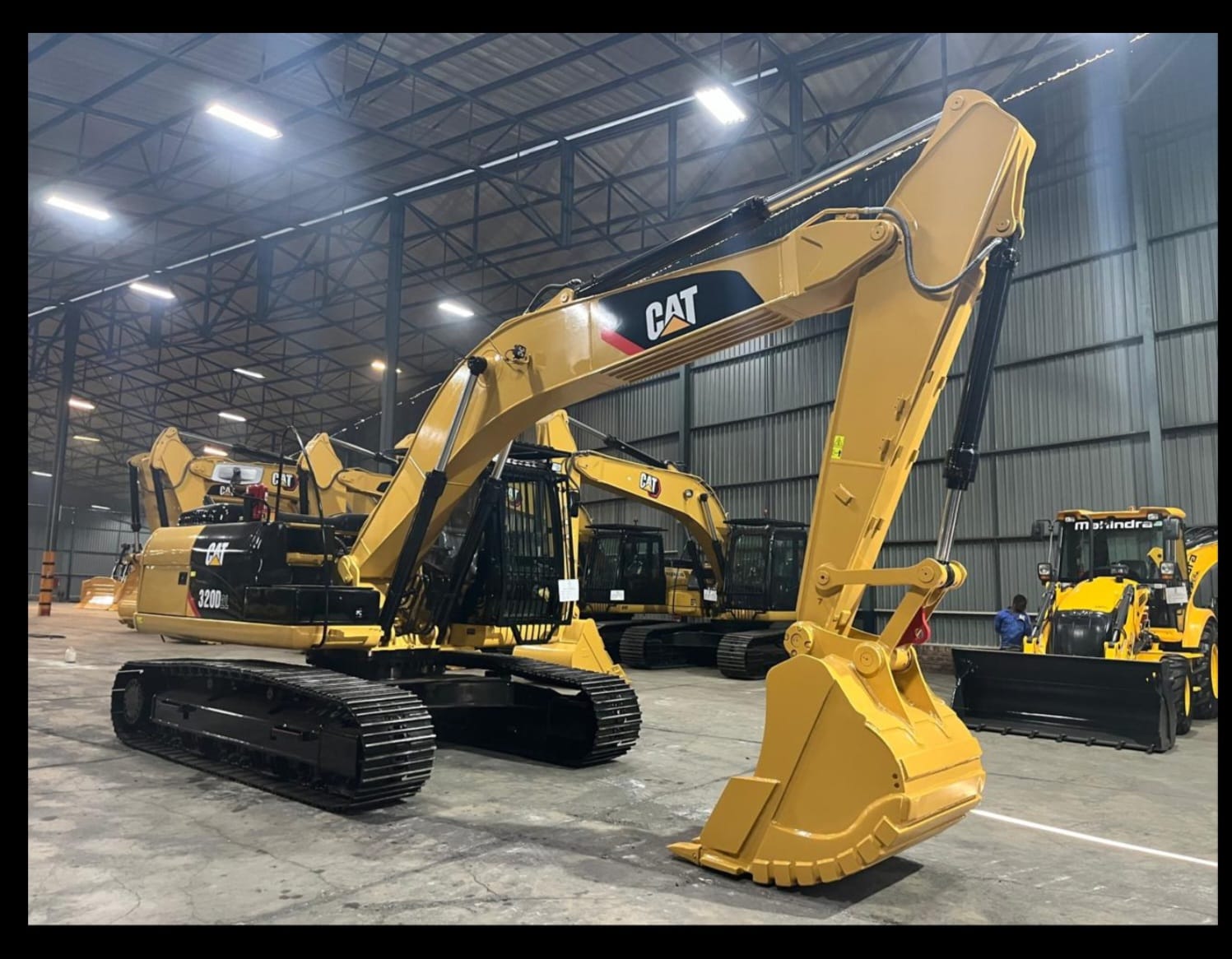 Caterpillar 320D excavators lined up in a warehouse