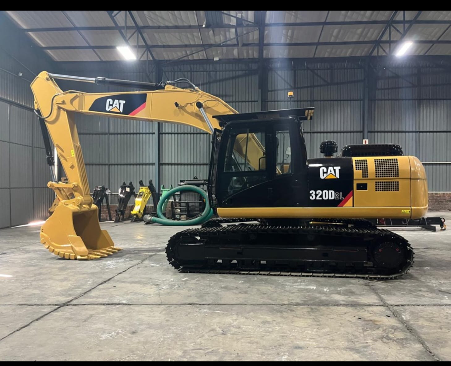 Caterpillar 320D2L excavator side profile inside the warehouse