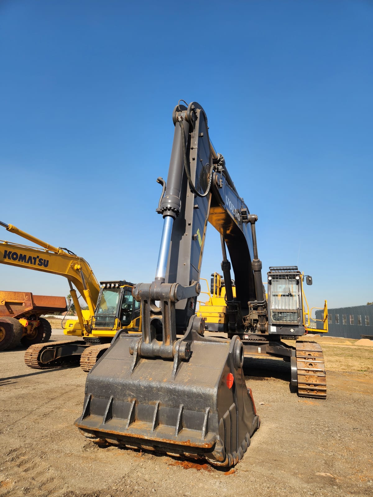 Front view of a Volvo excavator alongside a Komatsu machine