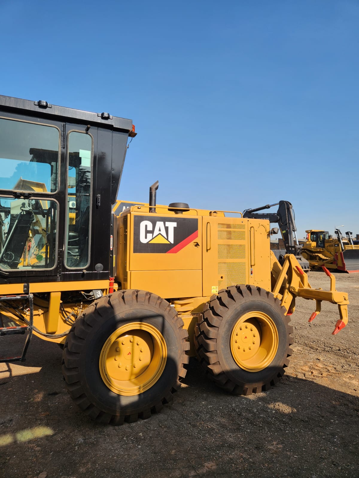 Rear view of a Caterpillar motor grader with ripper