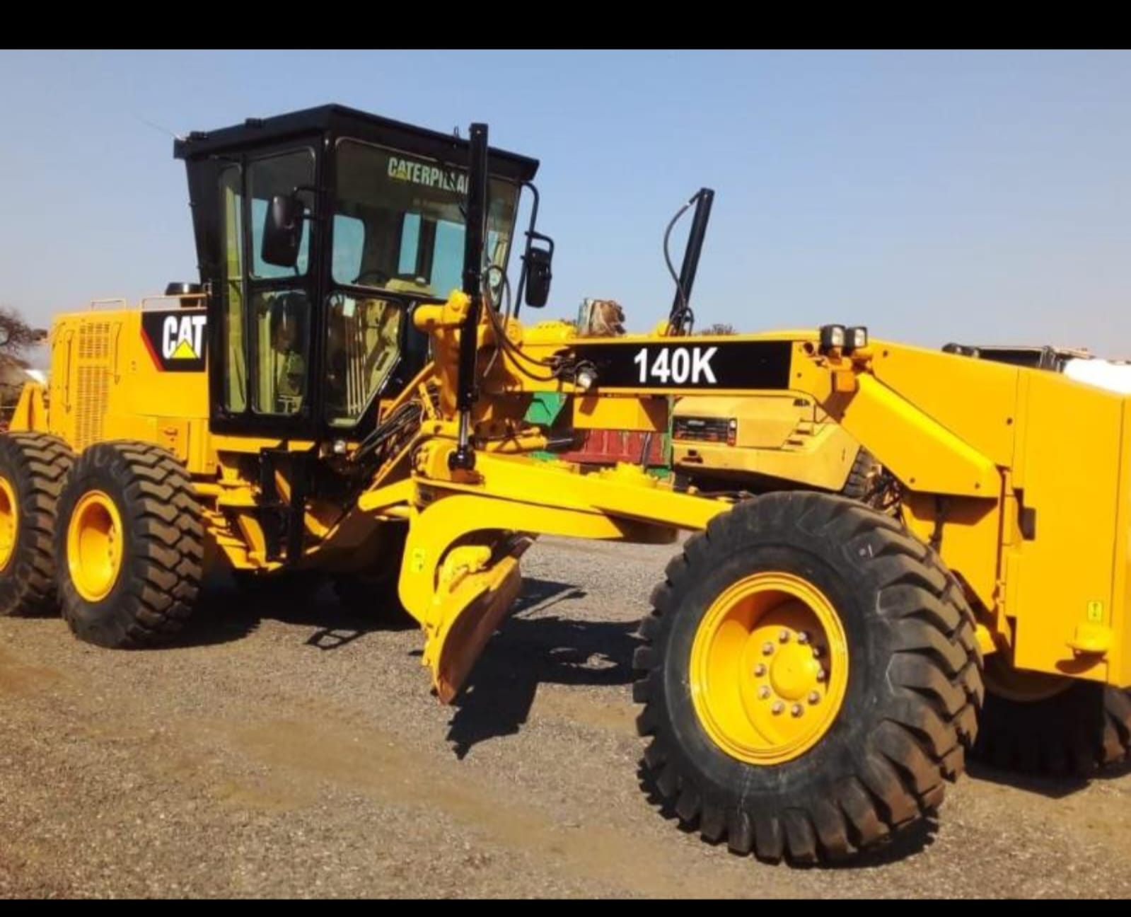 Caterpillar 140K motor grader on a gravel yard